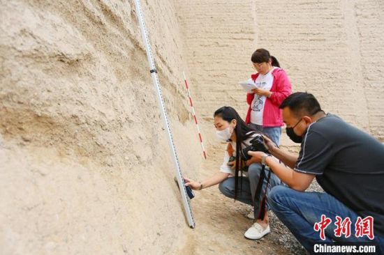 科技保護讓長城價值的真實性和完整性得到有效延續(xù)和傳承。圖為文物工作者正在測量關城的相關數(shù)據(jù)?！「哒?攝