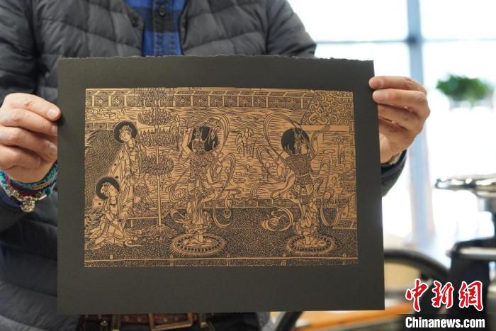 圖為手工書藝人展示敦煌雕版壁畫印刷品?！【琶赖┰?　攝