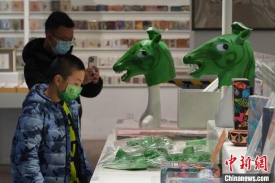 圖為“神馬來(lái)了”銅奔馬頭套吸引參觀者駐足?！【琶赖┰?攝