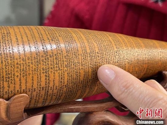 圖為長約二十公分的長條葫蘆雕刻佛教經(jīng)文作品?！堟?攝