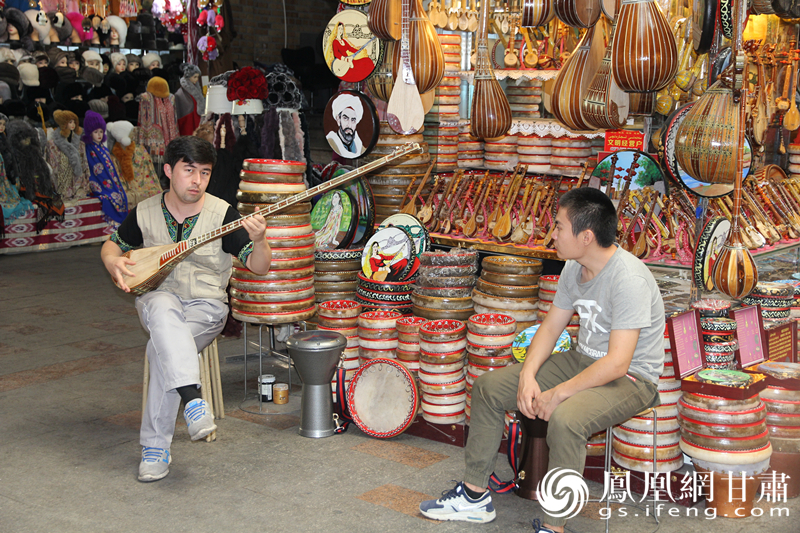 烏魯木齊二道橋巴扎內(nèi)，店主正在向客人展示樂器。楊文遠(yuǎn) 攝