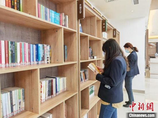 圖為在甘肅公航旅建設(shè)集團有限公司的職工書屋，職工挑選書籍?！⌒煅?攝
