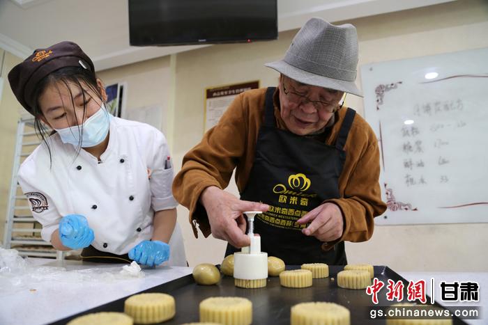 當(dāng)日，受邀參加活動(dòng)的臺(tái)胞臺(tái)屬代表、兩岸婚姻及子女、在甘臺(tái)商代表等歡聚一堂。圖為77歲的在甘臺(tái)胞潘天鑒制作月餅。九美旦增 攝