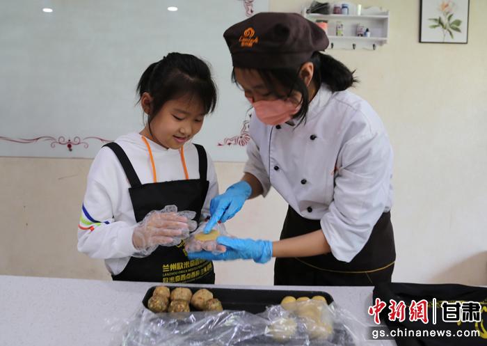 圖為在甘臺(tái)胞小朋友在工作人員指導(dǎo)下制作月餅。九美旦增 攝