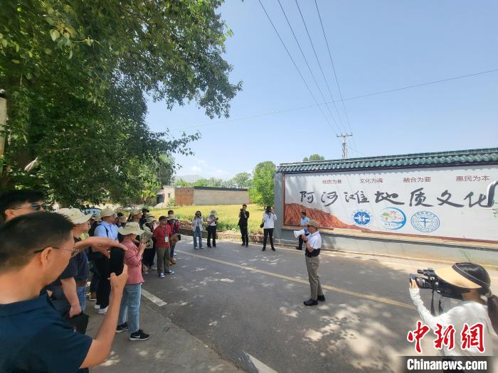 圖為中國地質(zhì)大學(xué)(北京)教授張緒教介紹村落情況?！『衍?攝