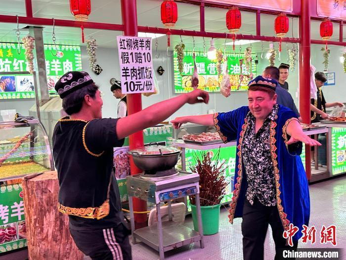 圖為餐飲經(jīng)營者在“西涼不夜城”跳起舞蹈引客?！〈魑牟?攝</p><p>