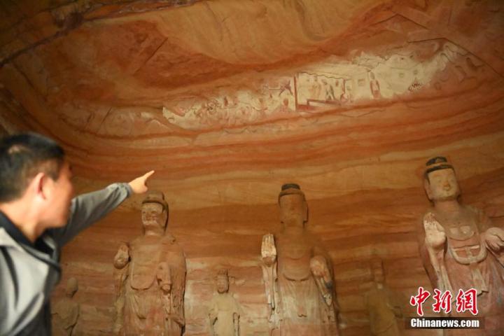 7月15日，甘肅省平涼市涇川縣百里石窟長廊中的南石窟寺1號窟內，工作人員介紹窟內僅存的浮雕——佛傳故事。百里石窟長廊位于涇川縣境內，由512個石窟、5眼窟中石井組成，現(xiàn)存王母宮石窟、鳳凰山石窟、南石窟寺、丈八寺石窟、羅漢洞石窟、太山寺石窟等規(guī)模較大的石窟群，還有數(shù)量眾多的小石窟群。南石窟寺開鑿于北魏永平三年，其中1號窟屬于大型七佛窟，七佛高達6米。中新社記者 李亞龍 攝</p>
<p>